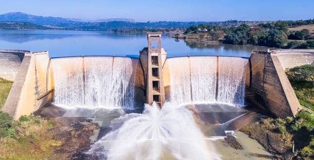 A dam wall overflowing in a picturesque background